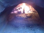Pizza cooking with fire burning ar rear.